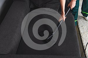 high angle view of person cleaning furniture with vacuum cleaner