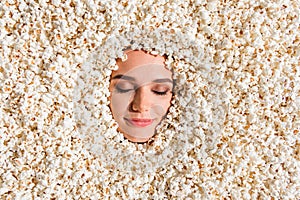 High angle view portrait of lovely positive peaceful girl face closed eyes smile buried pop corn background