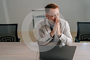 High-angle view portrait of pensive businessman in suit sit at desk with clasped palms thinking search problem solution