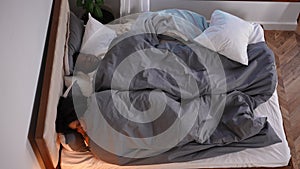 High angle view portrait of sleepless African American wife covering ears with hands as husband snoring sleeping in bed