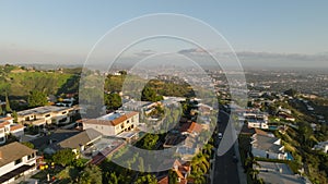 High angle view of rows of houses in luxurious residential neighbourhood in hills over metropolis. Tilt up reveal