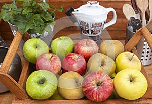 High angle view of a rustic wooden home corner with a basket full of apples on the table.  Many vitamins together and a mix of