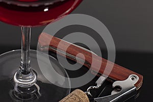 High angle view with shallow depth of field of a glass of red wine with a sommelier tools
