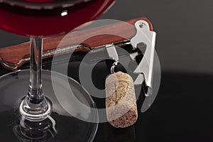 High angle view with shallow depth of field of a glass of red wine with a sommelier tools