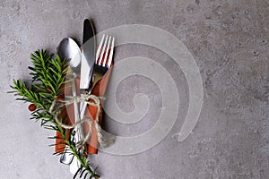 High Angle View of Silver Cutlery Set Wrapped in rope on Stylish grey background with copy space, Christmas dinner plate decoratio