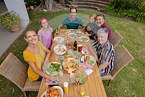 High angle view of smiling caucasian three generation family having celebration meal in garden