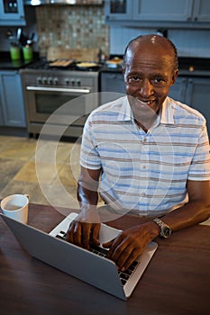 High angle view smiling senior man using laptop