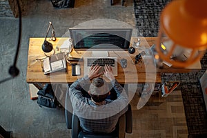 Top view of software developer working on a laptop at home