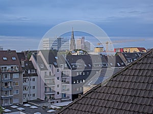 High angle view on the streets of Cologne, with tower ofSt. Mauritius church and apartment buildings in the blue hour