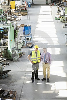 High angle view of supervisor and manual worker having discussion in metal industry