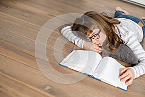 High angle view of teenage girl sleeping while studying on floor