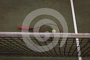 High angle view of tennis racket with ball and sports net on tennis court, copy space