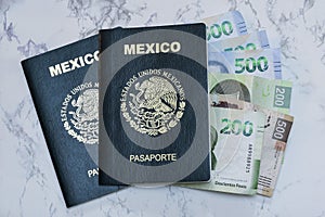 High angle view of two Mexican Passports and pesos on the table under the lights