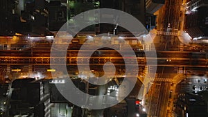 High angle view of vehicles driving on multilevel road surrounded with multistorey buildings in urban borough at night