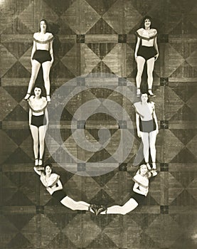 High angle view of women forming the letter U