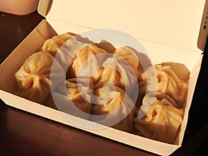 High angle view of Xiao Long Bao also called steamed soup dumplings in paper lunch box.