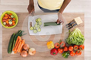 Young African Woman Chopping Vegetables In Kitchen