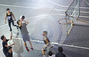 High angle view of young Asian people playing basketball outdoor at night