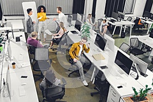 High angle view of young business colleagues working with papers and computers