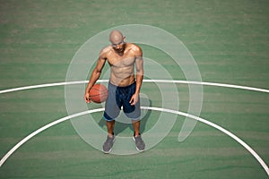 High angle view of young man, male basketball player playing basketball at street public stadium, sport court or