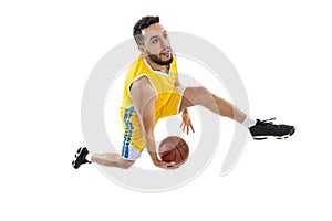 High angle view of young sportive man, professional basketball player jumping with ball isolated on white background