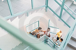 high angle view of young students walking down stairs