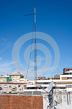 High antenna mast on the rooftop of a building