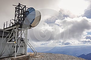 high antennas on the top of a mountain in austria with white clouds