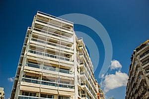 High apartment building from below point in city street environment in summer sunny clear weather time on blue sky background and
