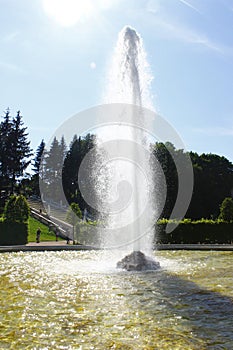 High beautiful fountain in the Park, on the background of blue s