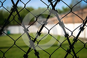 High brick wall behind barbed wires