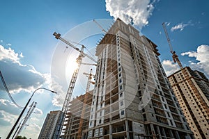 High building under construction with cranes and blue sky