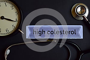 High Colesterol on the print paper with Healthcare Concept Inspiration. alarm clock, Black stethoscope. photo