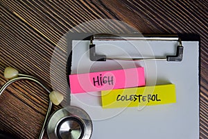 High Colesterol write on sticky notes isolated on Wooden Table photo