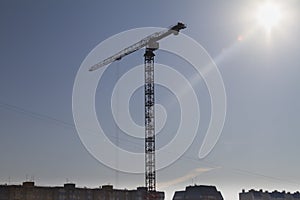 High construction crane against the background of urban development