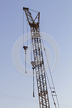 High construction crane on blue sky background