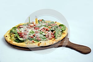 `A high contrast Hero shot of a Bruschetta Al Pesto Spinaci Pizza, on a minimal white background with a 30 degree angle from zoome