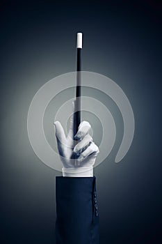 High contrast image of magician hand with magic wand