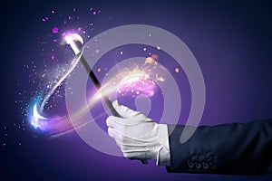 High contrast image of magician hand with magic wand photo