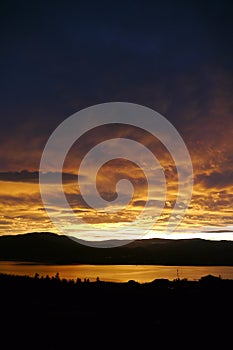 A high contrast view of a sunset in summer over the mountains