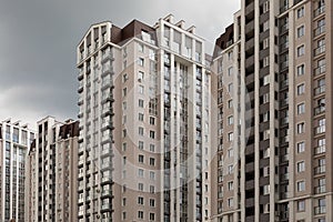 High density of people iving in modern high apartment building at cloudy sky background, diagonal view.