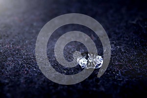 high detail close-up of sparkling drop of water on dark blue boild wool - bright light mood with deep shadows