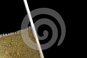 High detail of one flute tilted of champagne with golden bubbles