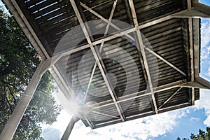 High diving board for training athletes, against the backdrop of the bright sun, blue sky and trees, outdoors.