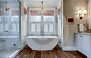 High end bathroom with large white bathtub and shiplap siding