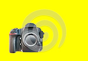 High end dslr camera front view, isolated on a yellow background