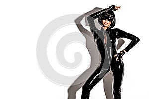 High fashion look. Glamour stylish beautiful young model in black latex clothing isolated on white background. Beauty stylish