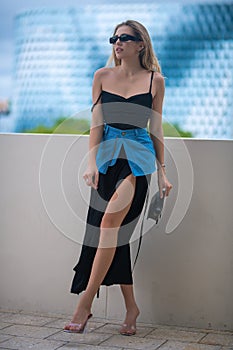 High fashion model walking on city street. Girl fashion style. Fashion beautiful elegant woman. Young woman wearing