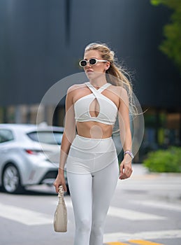 High fashion model walking on city street. Girl fashion style. Fashion beautiful elegant woman. Young woman wearing