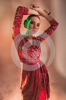 High Fashion model woman in colorful bright lights posing in studio,